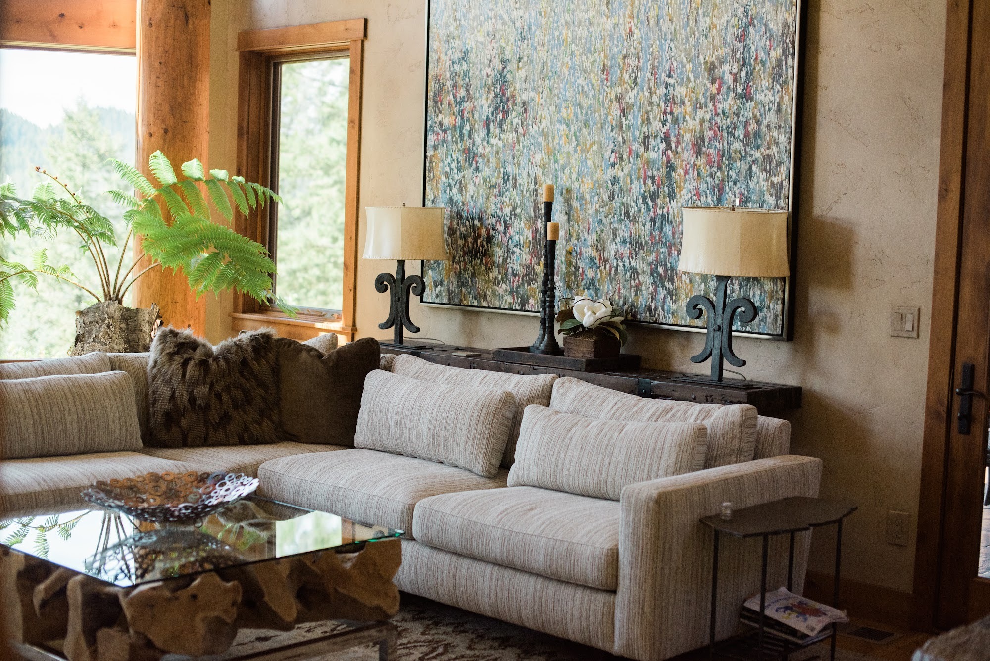 Sunlit living room with a curated gallery wall, sectional sofa, and mountain views