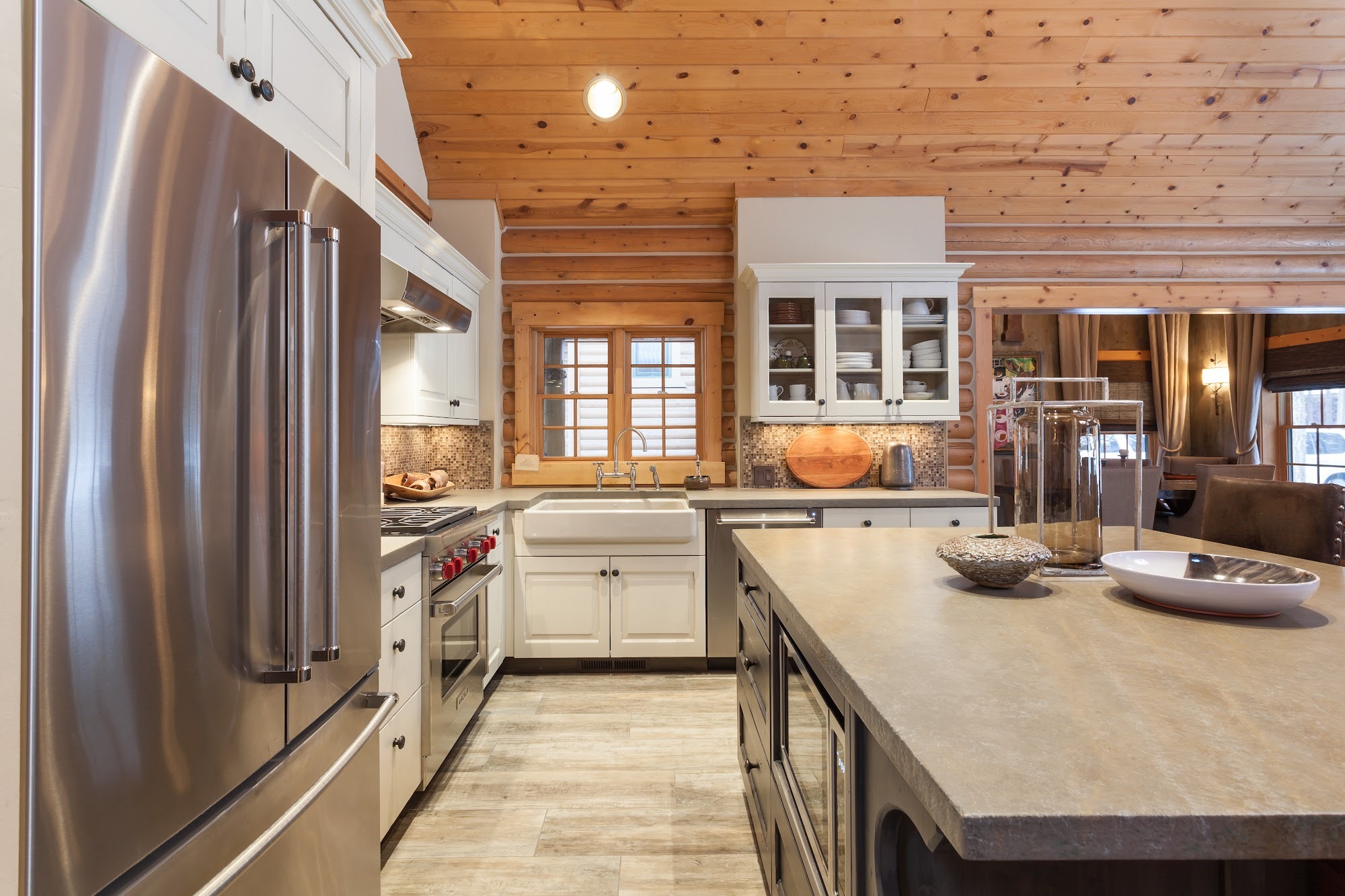 Log cabin kitchen with a farmhouse sink, stainless range, and mosaic tile backsplash
