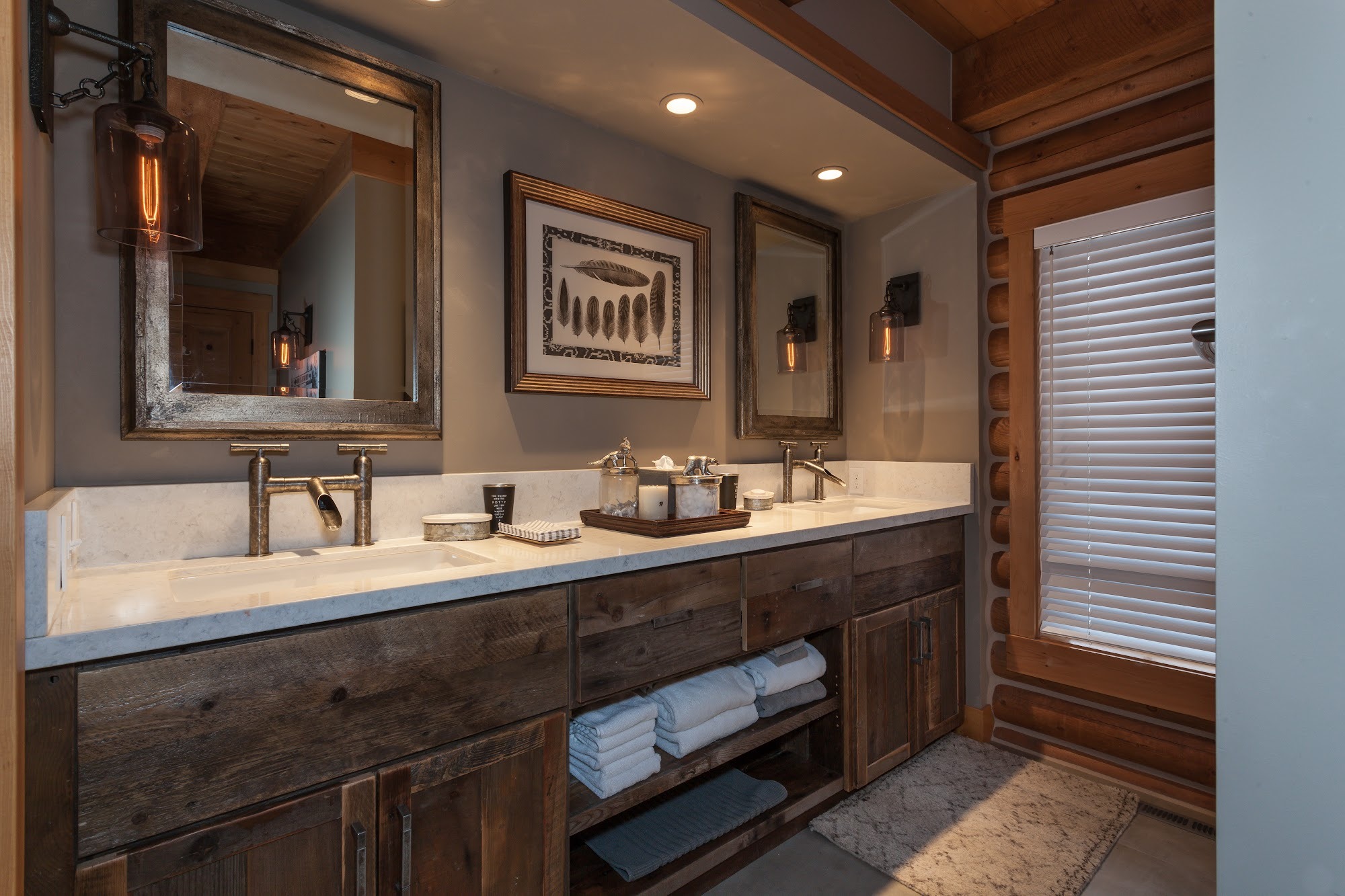 Rustic primary bathroom with a reclaimed wood double vanity and framed mirrors
