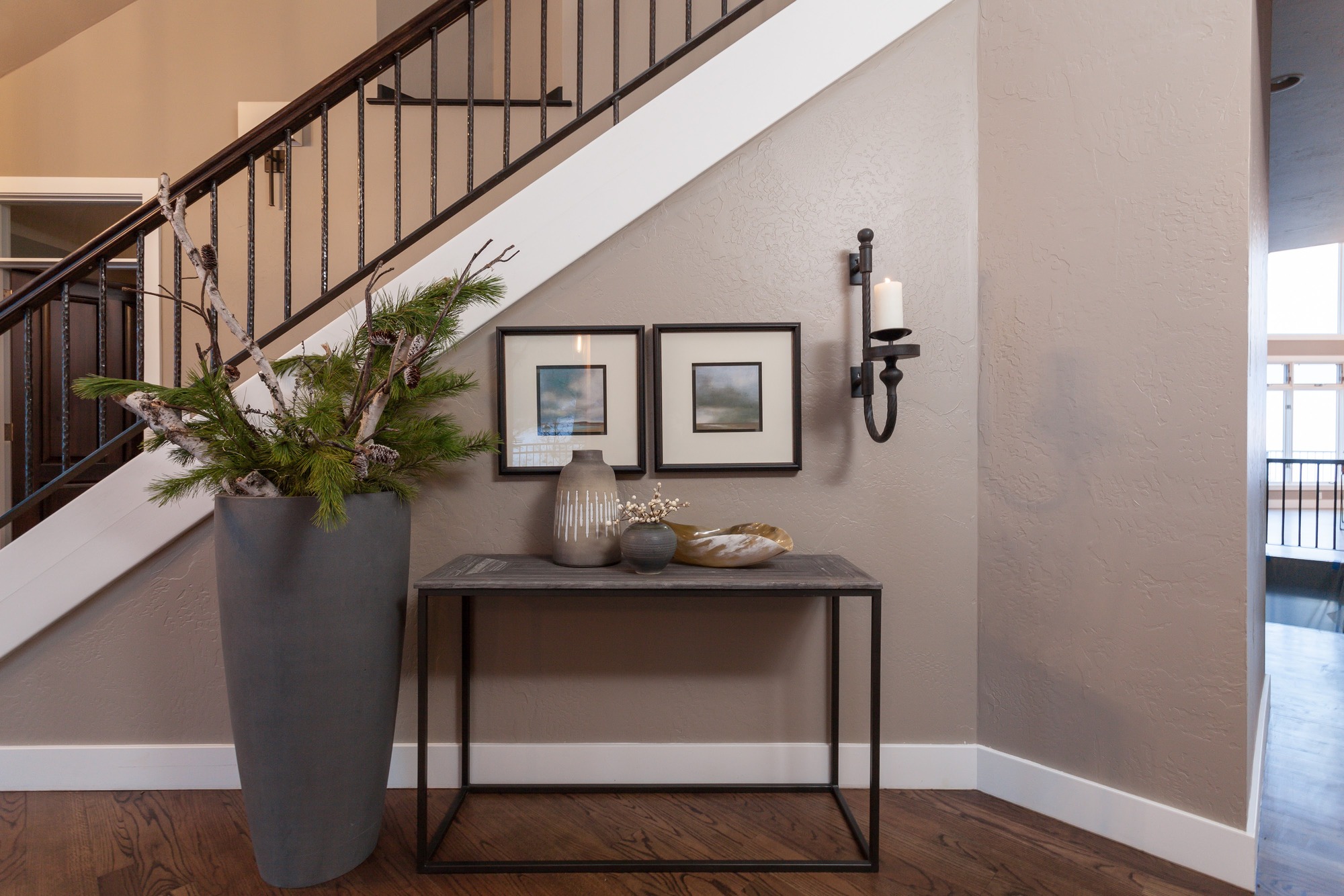 Entry vignette beneath a staircase with framed art and a console table